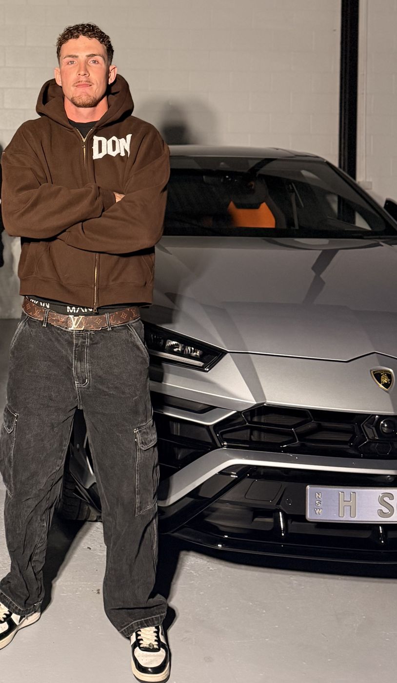 Jayess in a DON hoodie in front of a Lamborghini